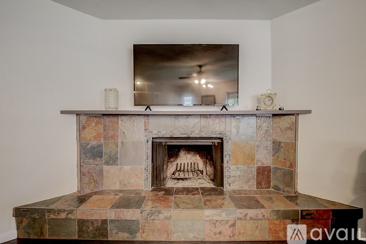 A fireplace with a mirror above it and a clock on the mantle.