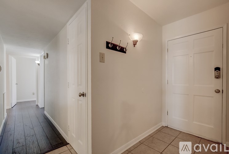A hallway with a wooden floor and white walls.