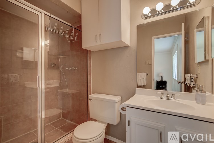 A bathroom with a toilet, sink, and shower.