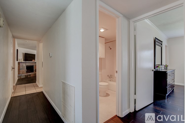 A long hallway with a bathroom at the end.