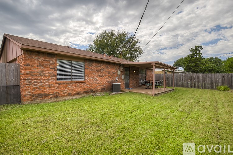 A house with a brown roof and a green lawn in front.