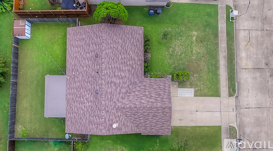 A house with a brown roof and a green lawn.