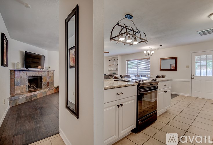 A kitchen with a fireplace and a chandelier.