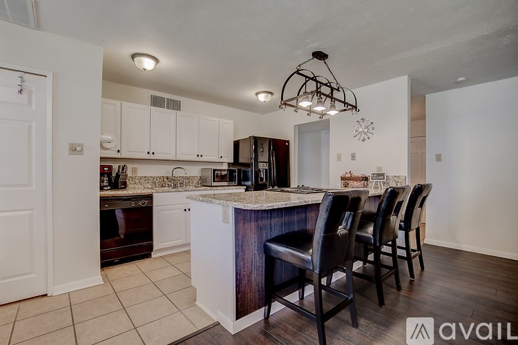 A kitchen with white cabinets and a marble countertop.