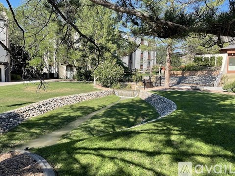 A stone pathway leads through a grassy area with trees.
