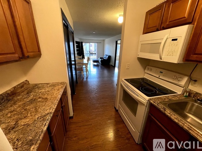 A kitchen with granite countertops and wooden cabinets.