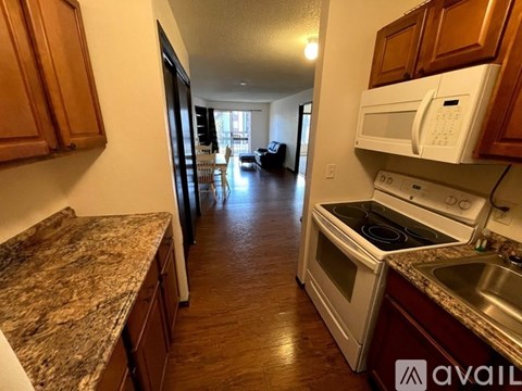 A kitchen with granite countertops and wooden cabinets.