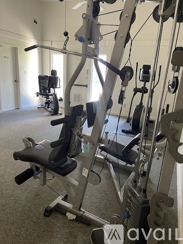 A gym with a row of exercise machines.