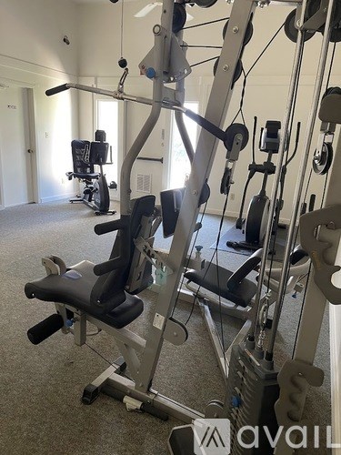 A gym with a row of exercise machines.