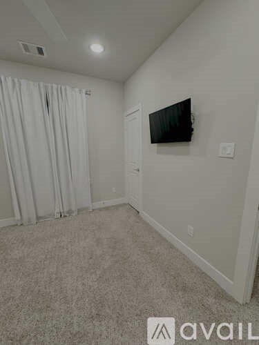 A room with a flat screen TV mounted on the wall.