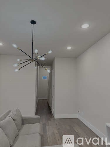 A living room with a couch and a chandelier.