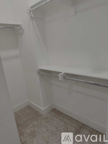 A bathroom with a white towel rack and a carpeted floor.