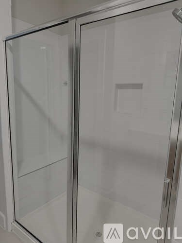 A glass shower door with a silver frame.