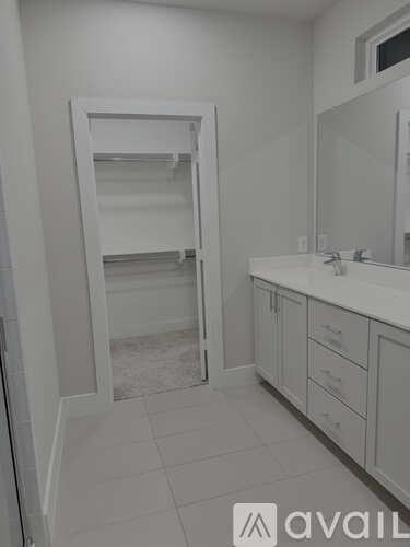 A bathroom with a white vanity and a large mirror.