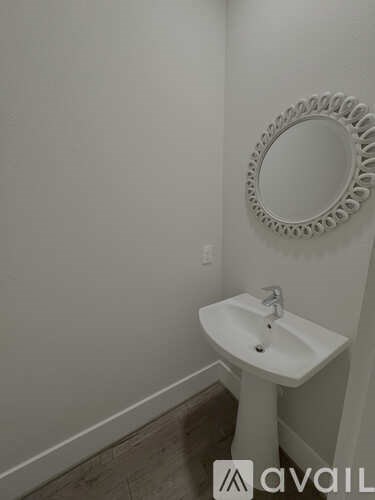 A bathroom with a white sink and mirror.