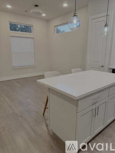 A kitchen with white cabinets and a large island.