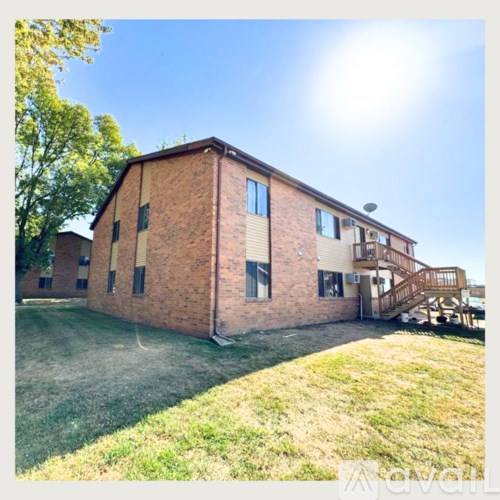 A red brick house with a staircase leading to the second floor.