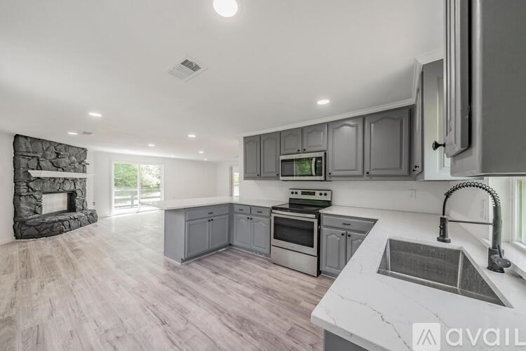 A modern kitchen with a stone fireplace and a marble countertop.