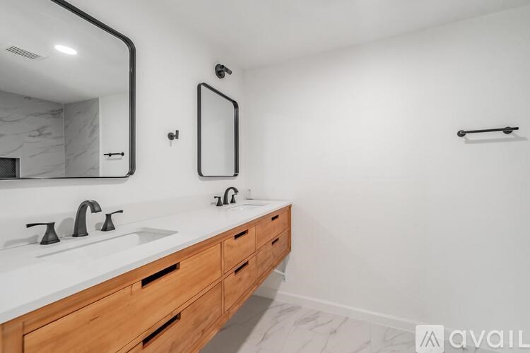 A bathroom with a marble countertop and a large mirror above the sink.