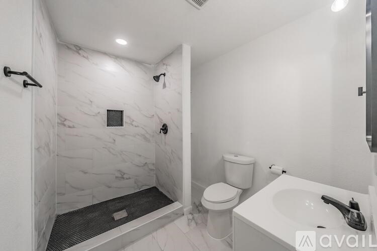 A bathroom with a marble wall and a walk-in shower.