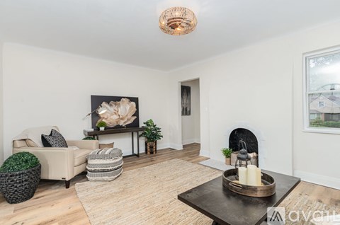A living room with a fireplace and a painting on the wall.