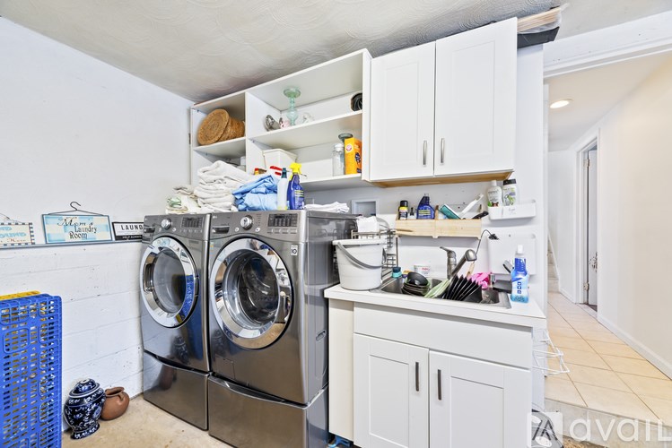 A laundry room with a washer and dryer, a sink, and a counter.
