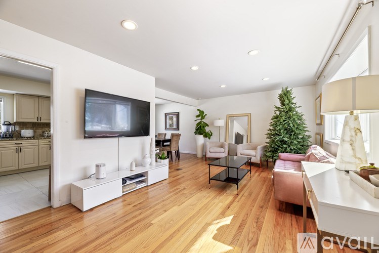 A living room with a television, a couch, a coffee table, and a Christmas tree.
