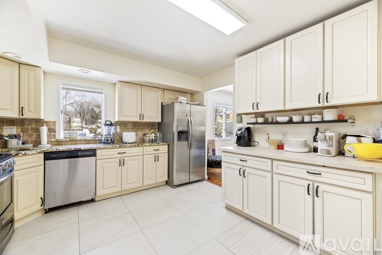 A kitchen with white cabinets and appliances.