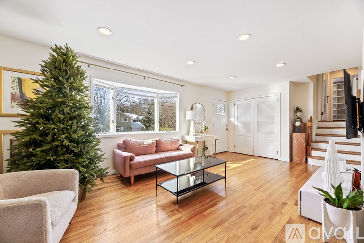 A living room with a Christmas tree and a couch.