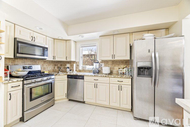 A kitchen with a stainless steel refrigerator, oven, and microwave.