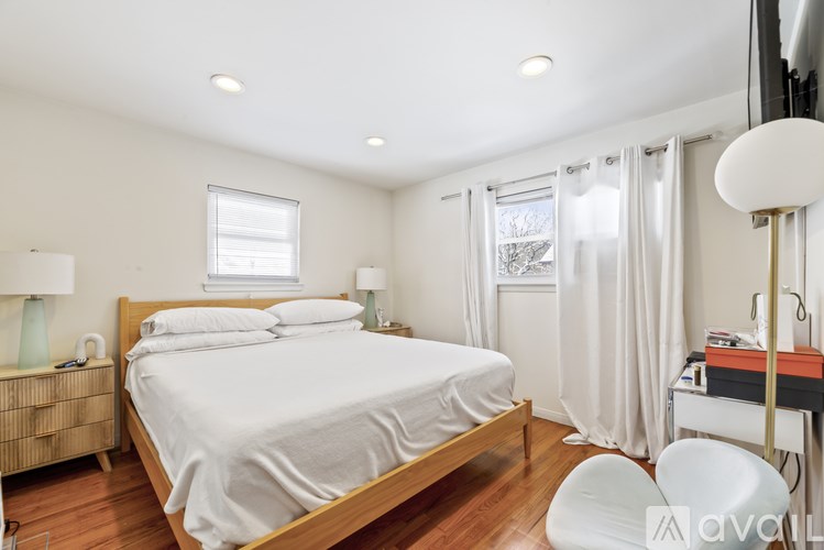 A bedroom with a large bed and a desk with a lamp.