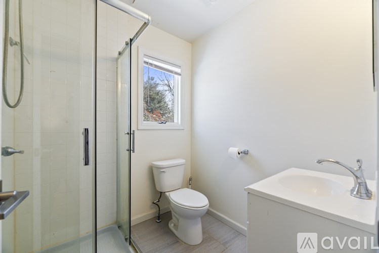 A bathroom with a toilet, sink, and shower.
