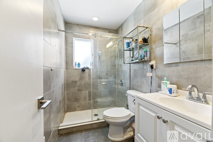 A bathroom with a toilet, sink, and shower.