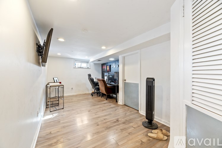 A room with a wooden floor and a speaker on the floor.