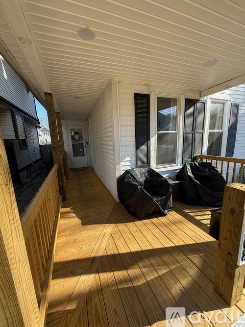 A wooden deck with a white house in the background.