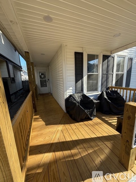 A wooden deck with a white house in the background.