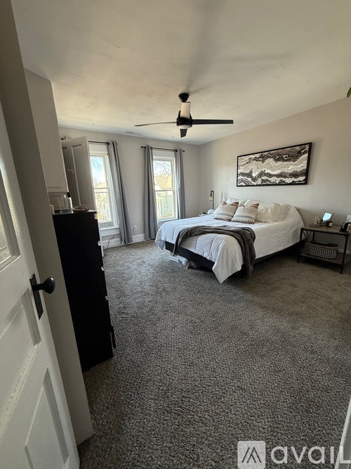 A bedroom with a bed, dresser, and window.