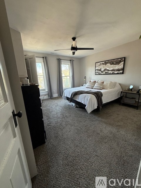 A bedroom with a bed, dresser, and window.