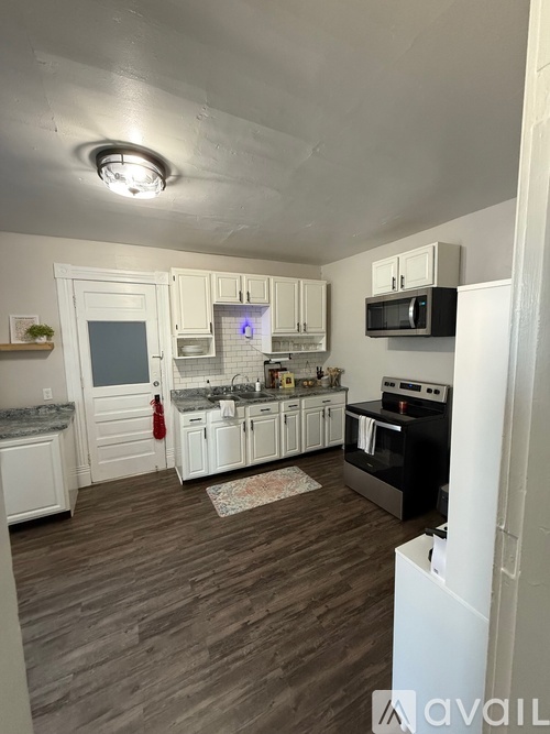 A kitchen with white cabinets and a black stove top oven.