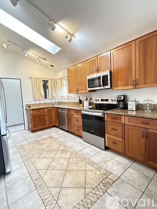 A kitchen with wooden cabinets and a tiled floor.
