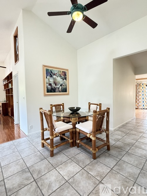 A dining room with a table and chairs.