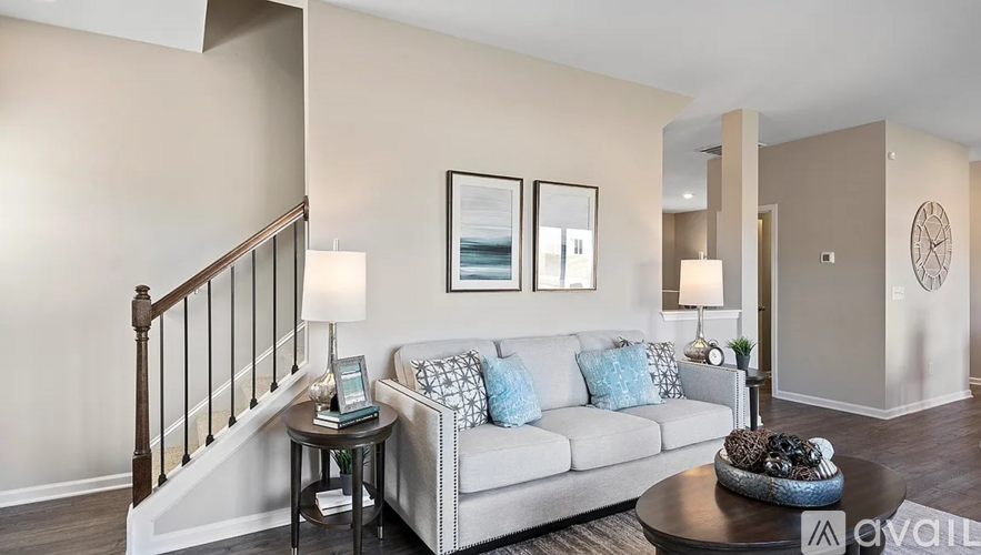 A living room with a couch, a table, and a staircase.
