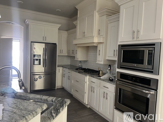 A kitchen with white cabinets and stainless steel appliances.