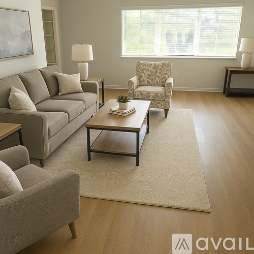 A living room with a grey sofa, a grey armchair, a wooden coffee table, and a rug.