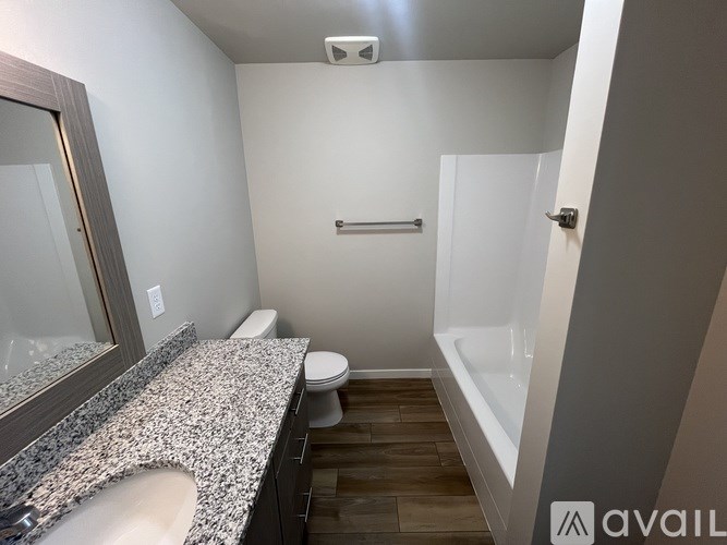 A bathroom with a granite countertop and a white toilet.