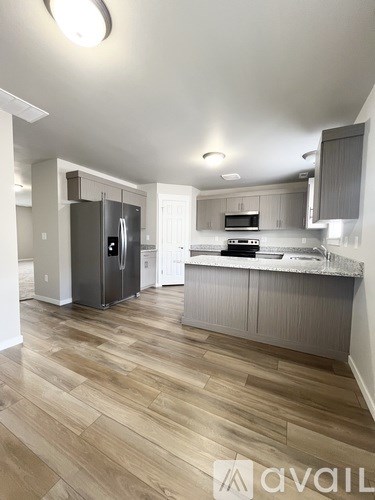 A kitchen with a refrigerator, microwave, and oven.