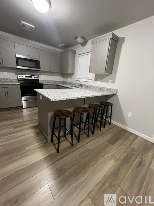 A white door is open to a small, empty room with a grey carpet.