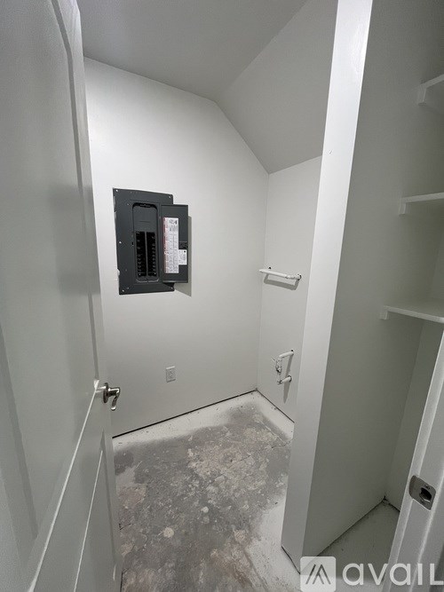 A bathroom with a white door and a white wall.