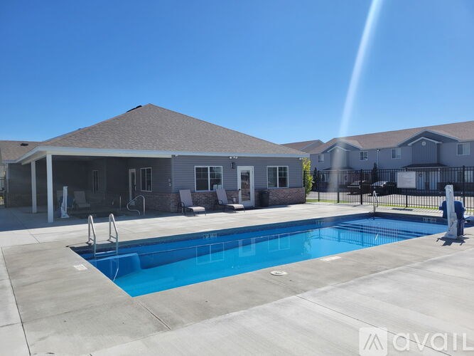 A pool in front of a house with a sign that says "AVAIL".