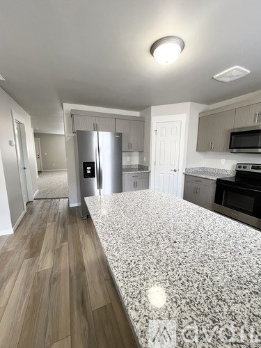 A kitchen with a granite countertop and stainless steel appliances.